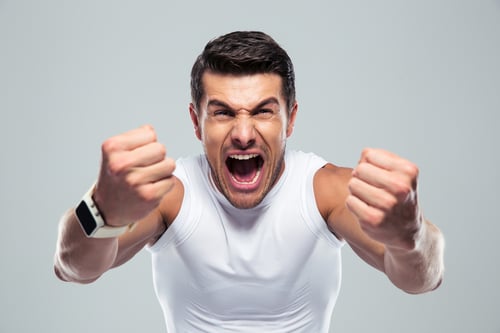 Excited fitness man shouting at camera over gray background