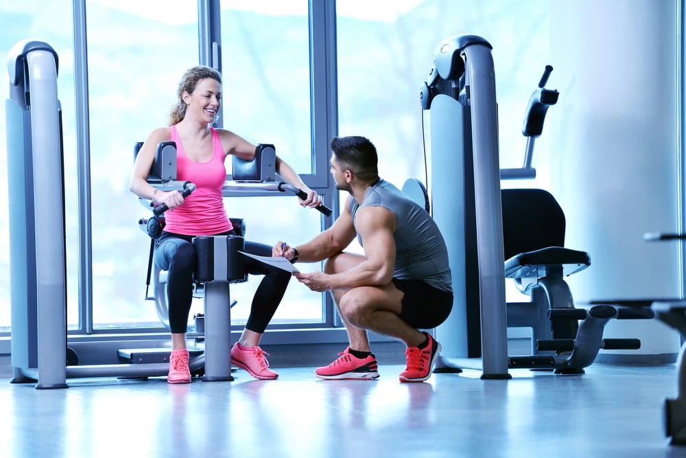 Gym woman exercising with her personal trainer