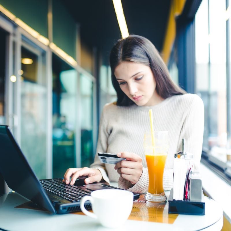 Student with Credit card at a cafe table